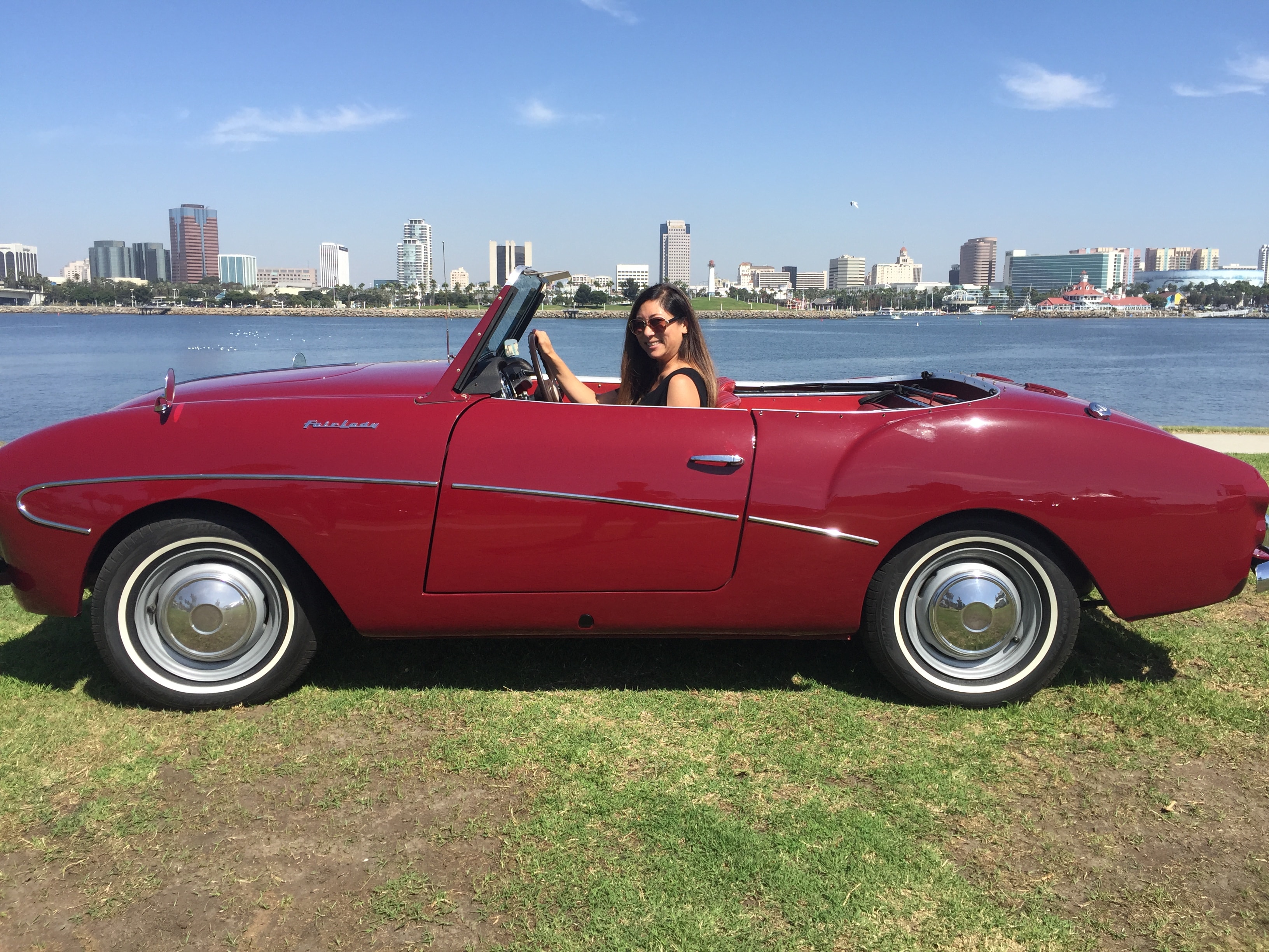 Michelle Suzuki with a classic red convertible at the waterfront